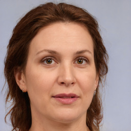 Joyful white adult female with medium  brown hair and green eyes