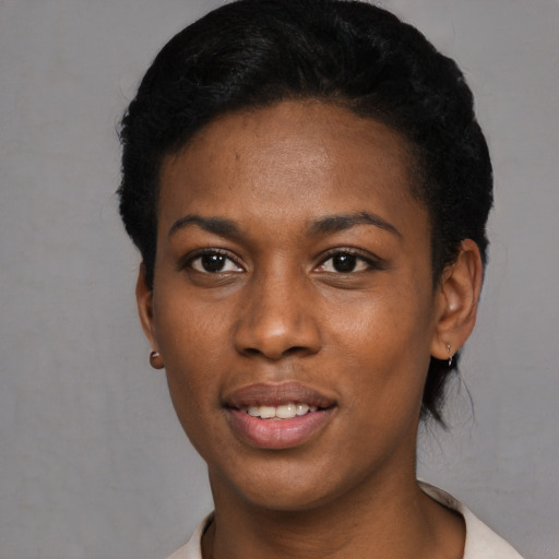 Joyful black young-adult female with short  black hair and brown eyes