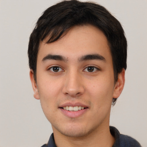 Joyful white young-adult male with short  black hair and brown eyes