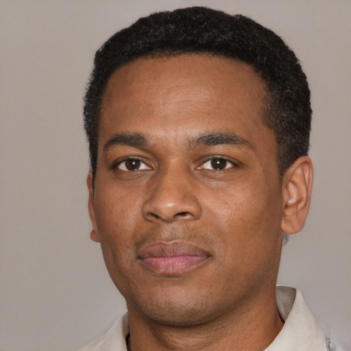 Joyful black young-adult male with short  black hair and brown eyes