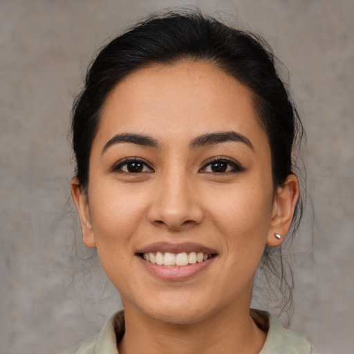 Joyful latino young-adult female with medium  brown hair and brown eyes