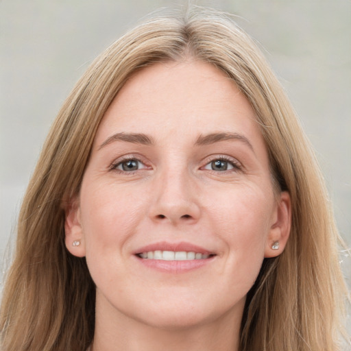 Joyful white adult female with long  brown hair and grey eyes