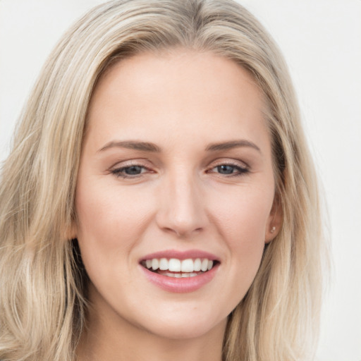 Joyful white young-adult female with long  brown hair and blue eyes