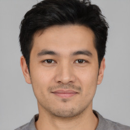 Joyful asian young-adult male with short  black hair and brown eyes