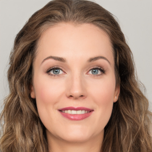 Joyful white young-adult female with long  brown hair and green eyes