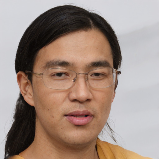 Joyful asian adult male with long  brown hair and brown eyes