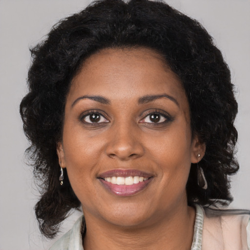 Joyful black young-adult female with long  brown hair and brown eyes