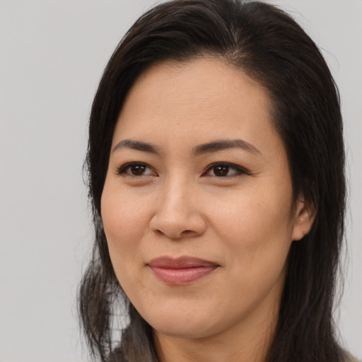 Joyful asian adult female with long  brown hair and brown eyes