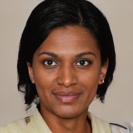 Joyful black young-adult female with medium  black hair and brown eyes