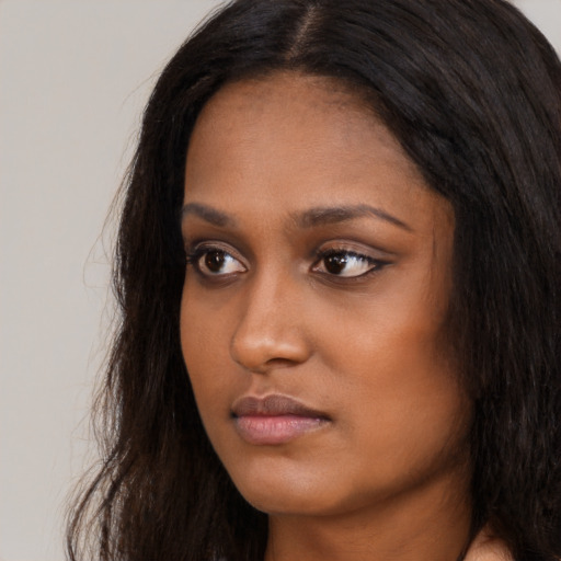 Neutral black young-adult female with long  brown hair and brown eyes