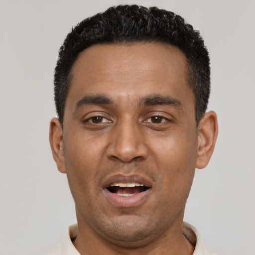 Joyful black adult male with short  black hair and brown eyes
