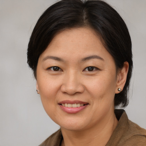 Joyful asian young-adult female with medium  brown hair and brown eyes
