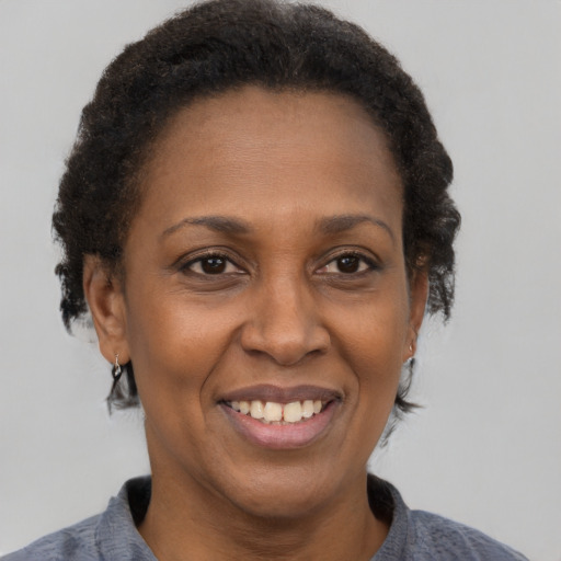 Joyful black adult female with short  brown hair and brown eyes