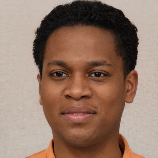 Joyful black young-adult male with short  brown hair and brown eyes