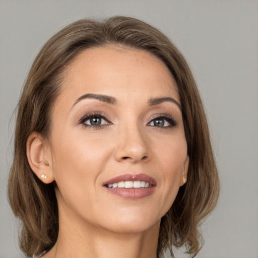 Joyful white young-adult female with medium  brown hair and grey eyes