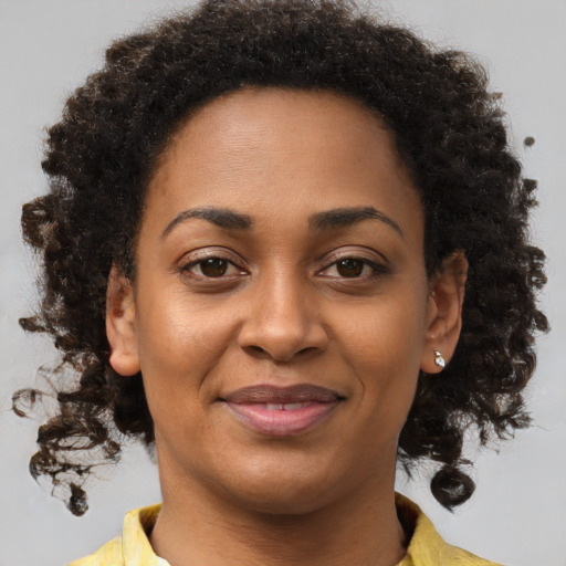 Joyful black young-adult female with short  brown hair and brown eyes