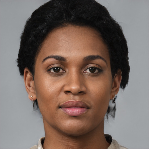 Joyful black young-adult female with short  black hair and brown eyes