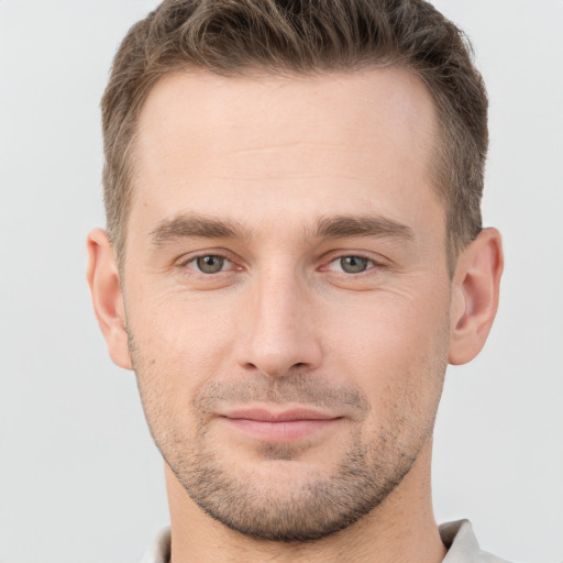 Joyful white young-adult male with short  brown hair and grey eyes