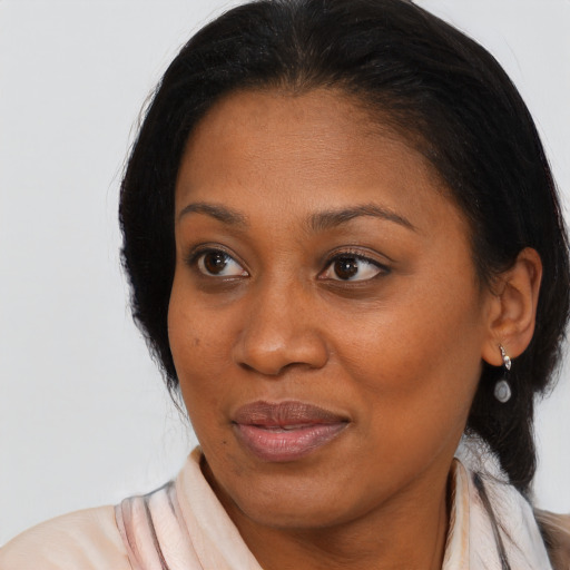 Joyful black adult female with medium  brown hair and brown eyes