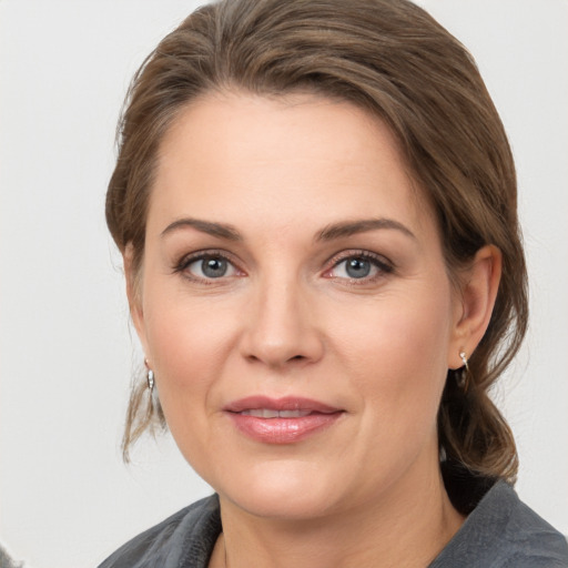 Joyful white young-adult female with medium  brown hair and grey eyes