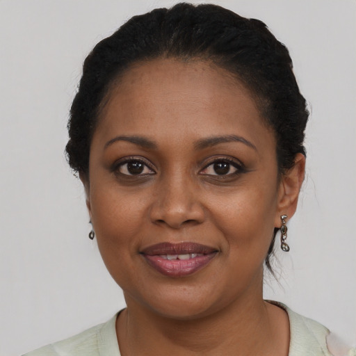 Joyful black adult female with short  black hair and brown eyes