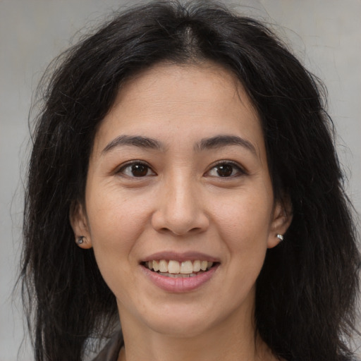 Joyful latino young-adult female with medium  brown hair and brown eyes