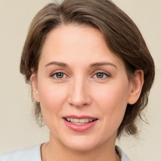 Joyful white young-adult female with medium  brown hair and green eyes