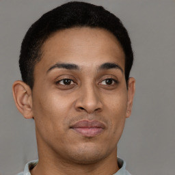 Joyful latino young-adult male with short  brown hair and brown eyes