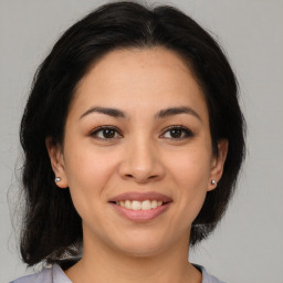 Joyful latino young-adult female with medium  brown hair and brown eyes