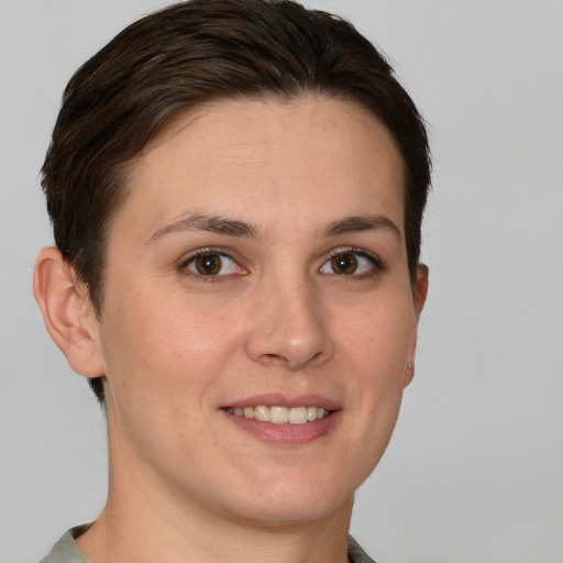 Joyful white young-adult female with short  brown hair and grey eyes