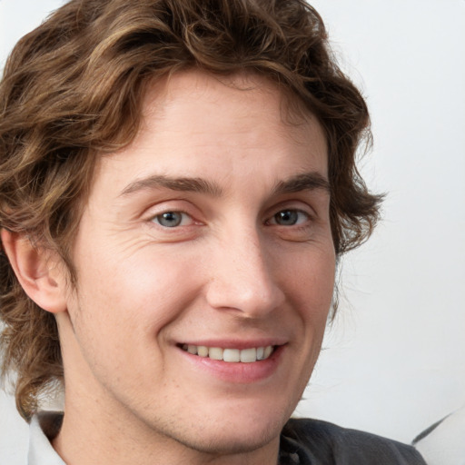 Joyful white young-adult male with medium  brown hair and grey eyes