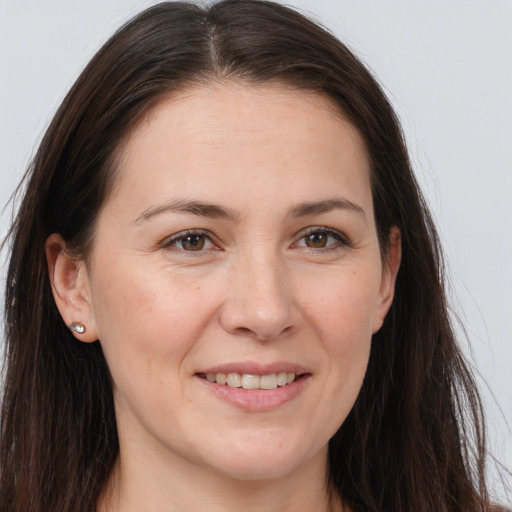 Joyful white young-adult female with long  brown hair and brown eyes