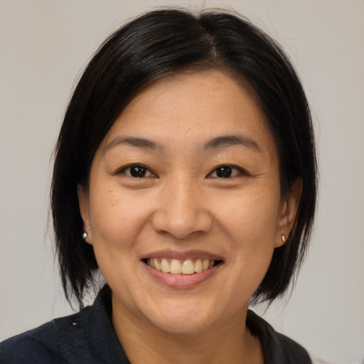 Joyful asian adult female with medium  brown hair and brown eyes