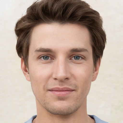 Joyful white young-adult male with short  brown hair and grey eyes