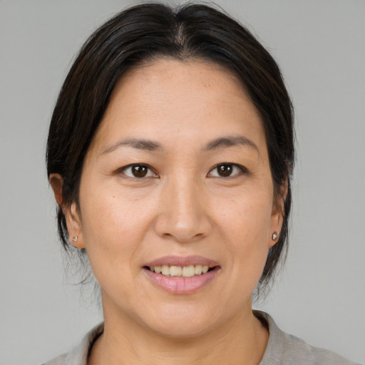 Joyful asian adult female with medium  brown hair and brown eyes