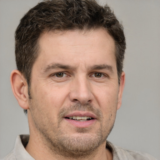 Joyful white adult male with short  brown hair and brown eyes