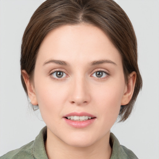 Joyful white young-adult female with medium  brown hair and grey eyes