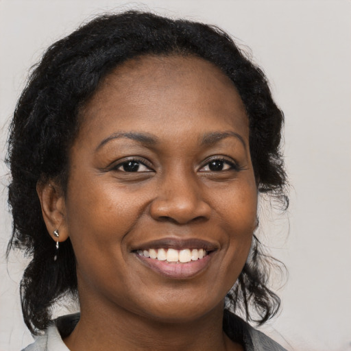 Joyful black young-adult female with medium  brown hair and brown eyes