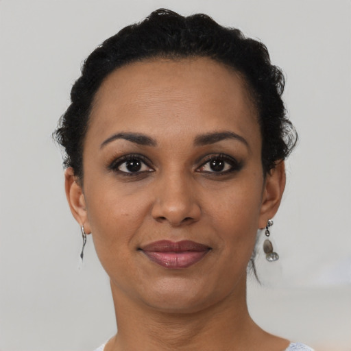 Joyful black young-adult female with short  brown hair and brown eyes