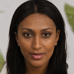 Joyful black young-adult female with long  brown hair and brown eyes