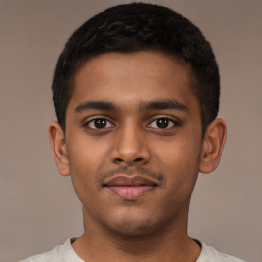 Joyful black young-adult male with short  black hair and brown eyes