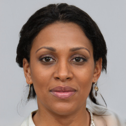 Joyful black adult female with medium  brown hair and brown eyes