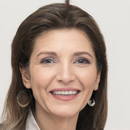 Joyful white adult female with long  brown hair and grey eyes