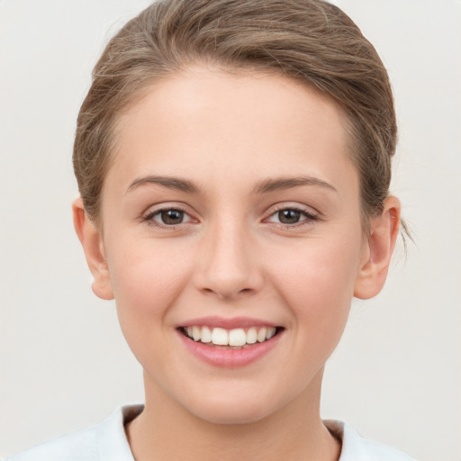 Joyful white young-adult female with short  brown hair and grey eyes