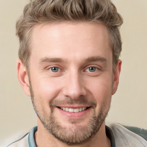 Joyful white young-adult male with short  brown hair and grey eyes