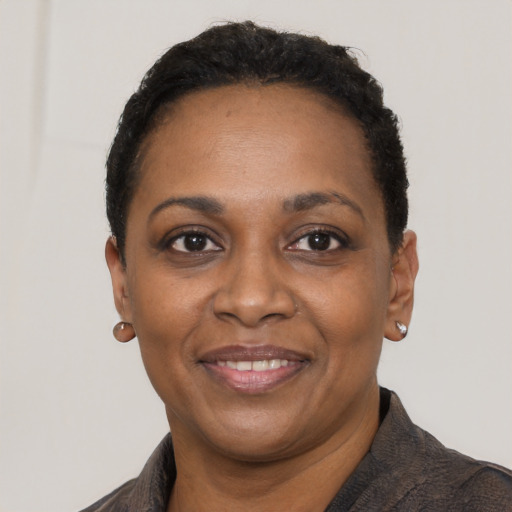 Joyful black adult female with short  black hair and brown eyes