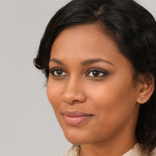 Joyful black young-adult female with medium  brown hair and brown eyes