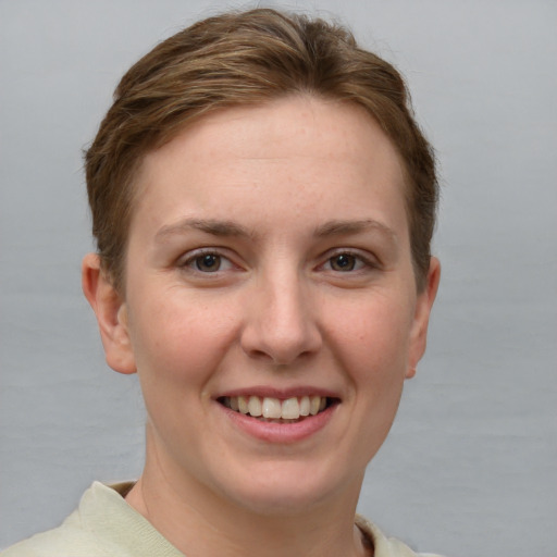 Joyful white young-adult female with short  brown hair and grey eyes