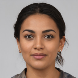 Joyful latino young-adult female with medium  brown hair and brown eyes