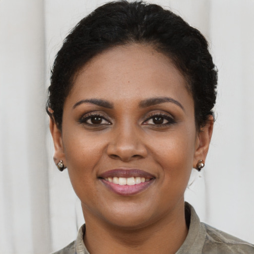 Joyful black young-adult female with long  brown hair and brown eyes